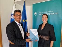 Peter Svetina hands over the 2022 Annual Report to Dr Ana Kerševan