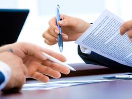 Two people with pens in their hands