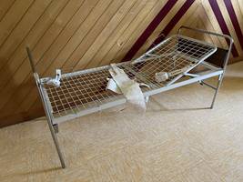 Wire bed frame with straps for tying down mental patients
