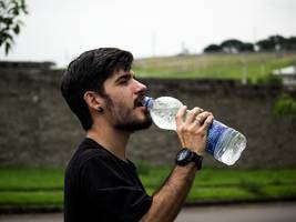 Moški pije vodo iz plastenke