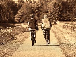 Two women are riding bicycles